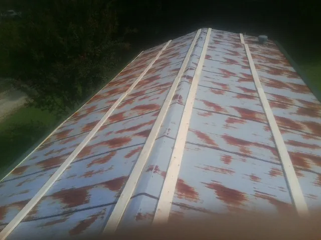 Rusted metal roof panels with new wood purlins before replacement — Storm Damage Roof Repair in Marbury by Roofing Brothers