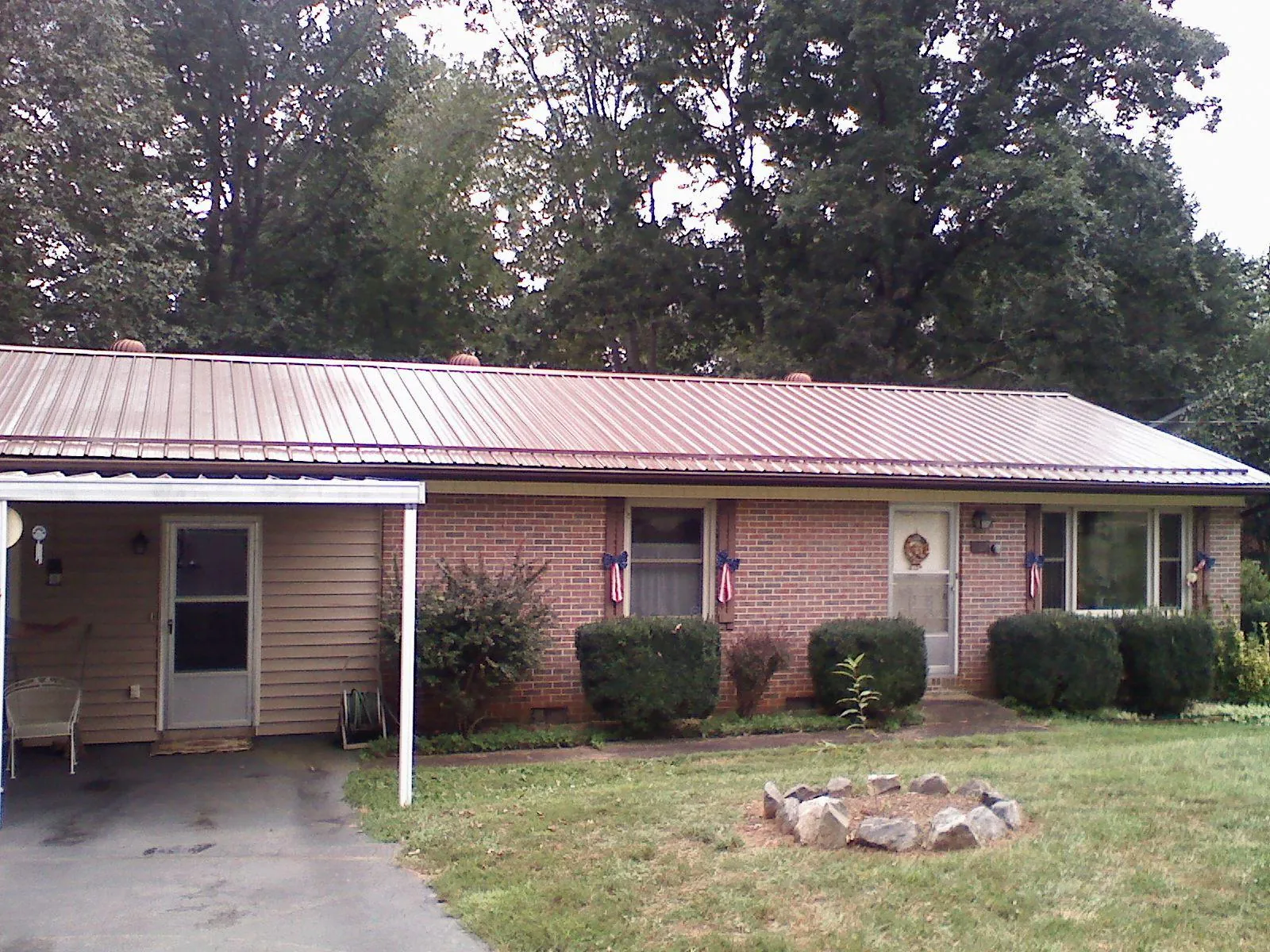 Bronze metal roof and carport on a brick ranch home — Roof Repair work by our crew in Marbury